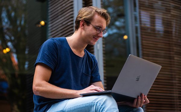 Person seated looking at laptop Person seated looking at laptop